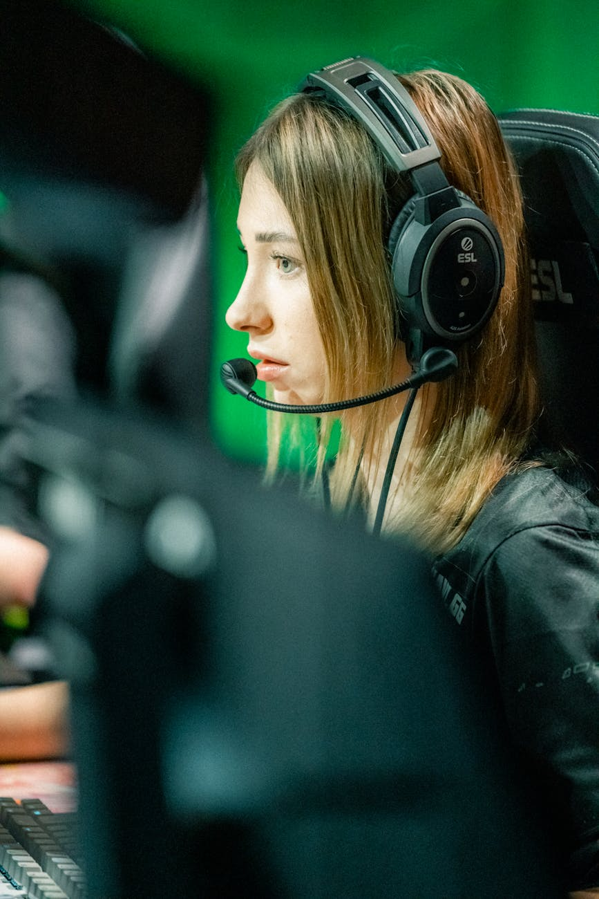 focused female gamer with headset in action